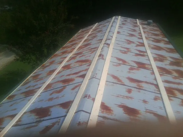 Rusted metal roof panels with new wood purlins before replacement — Storm Damage Roof Repair in Box Springs by Roofing Brothers