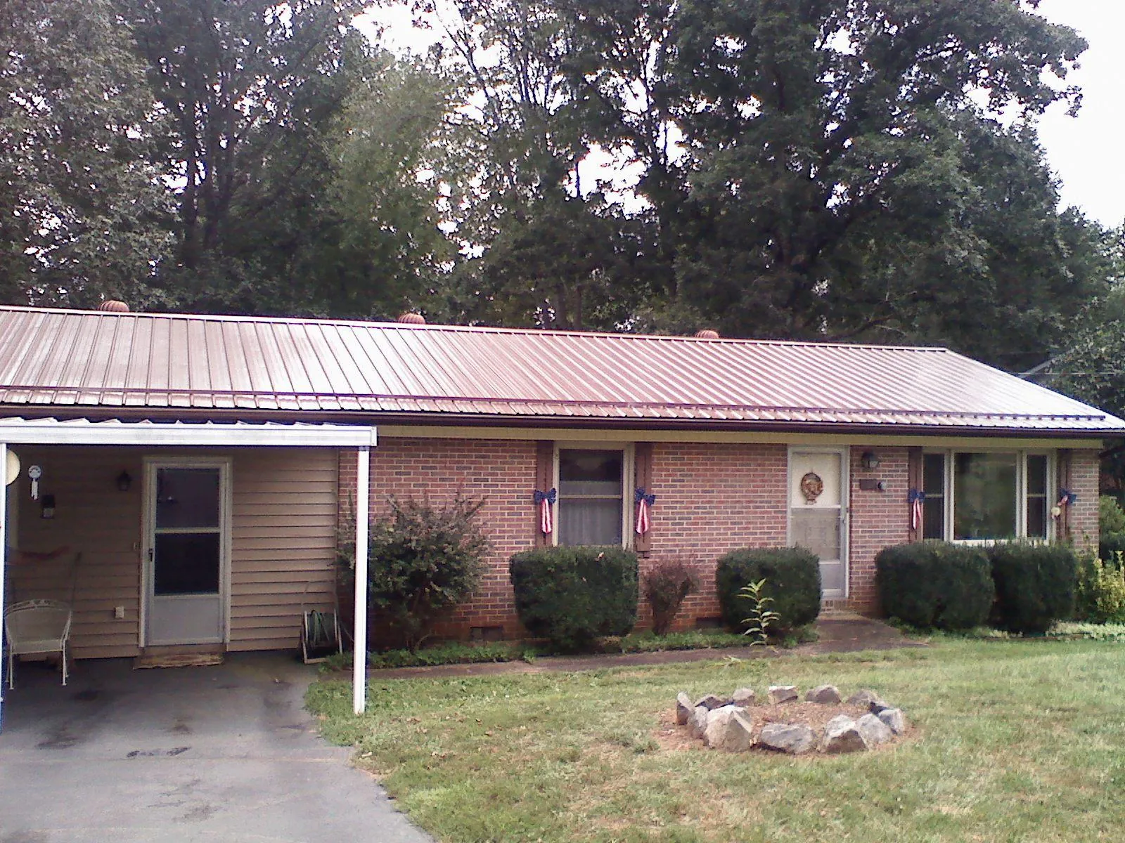 Bronze metal roof and carport on a brick ranch home — Roof Repair work by our crew in Box Springs